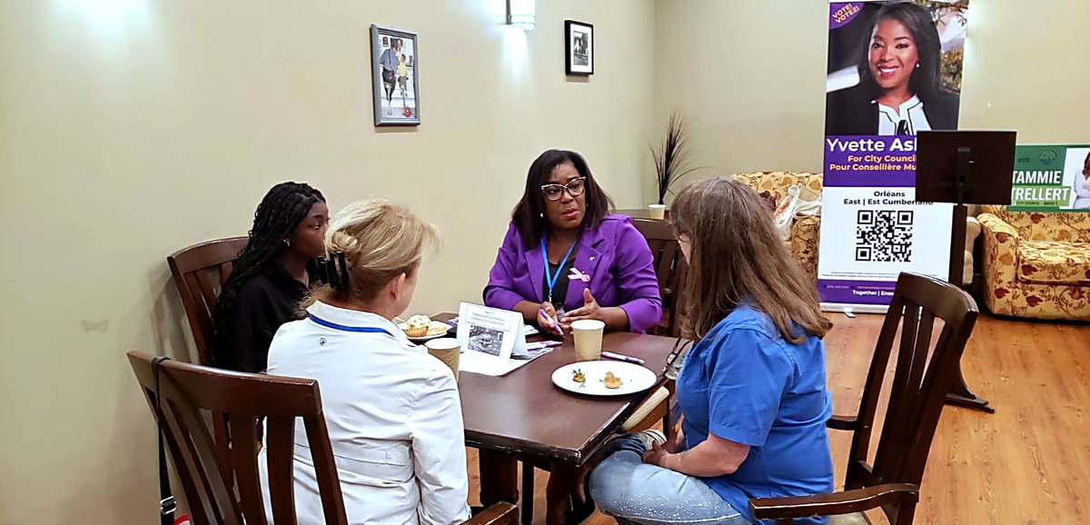 Yvette en plein &eacute;change avec trois participantes autour d'une table avant le panel du CFFLO